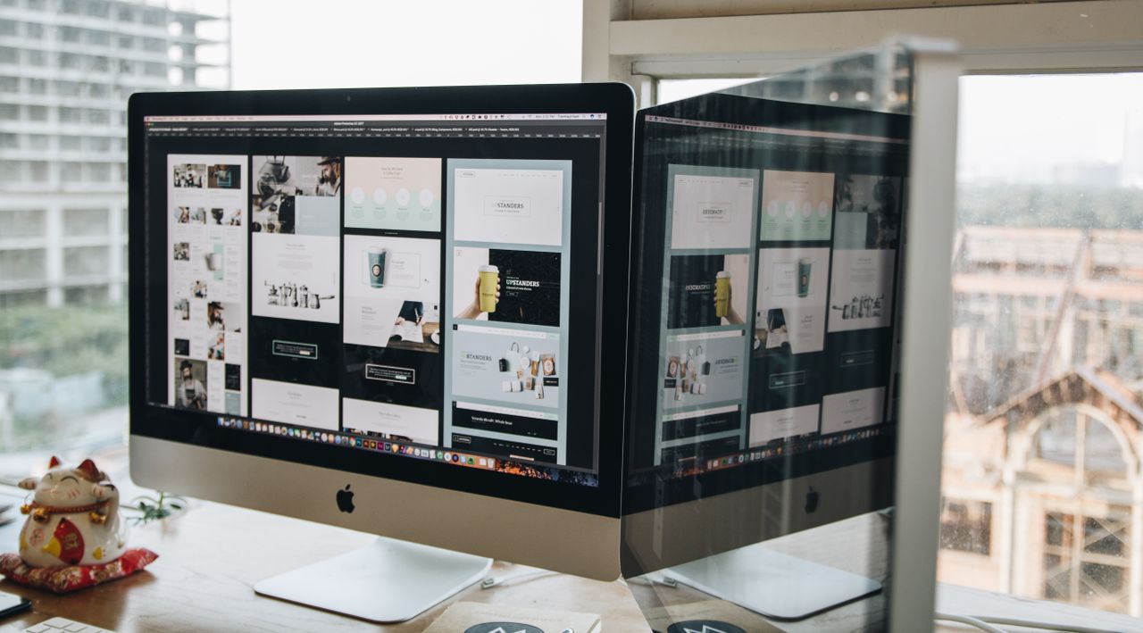 Deux écrans posés sur un bureau, illustrant la conception web dans un environnement de bureau moderne.